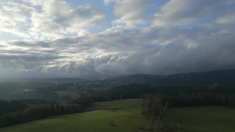breathtaking view of a landscape with rolling hills, green fields, and a sky filled with fluffy clouds