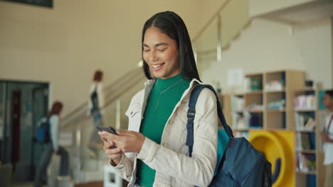 young student in library using phone