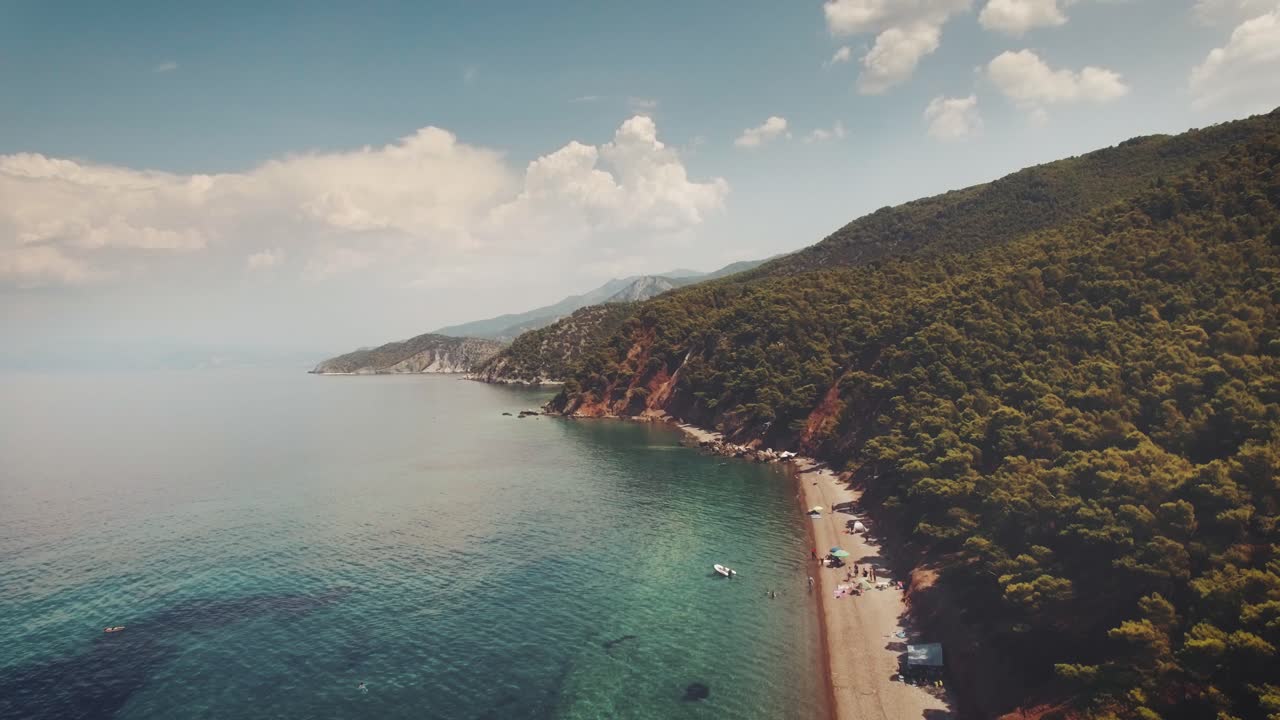 aerial footage of an exotic beach with crystal clear turquoise waters in Greece at summer 3