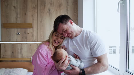 happy new-made parent can't take away their eyes from their son. family of three in the hospital after childbirth.
