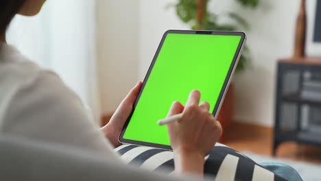 close up de mujer sosteniendo en las manos una tableta digital con pantalla verde para internet en línea, pantalla chromakey para publicidad.