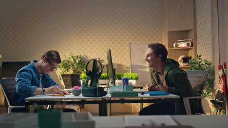 compañeros despreocupados divirtiéndose en la oficina hipster. hombre feliz arrojando papel arrugado