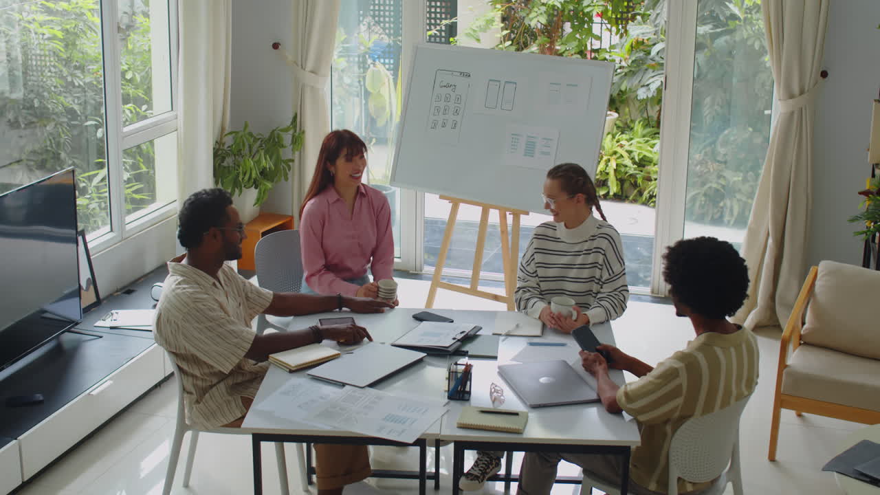 Startup Workers Meeting at Office Desk to Discuss Plans
