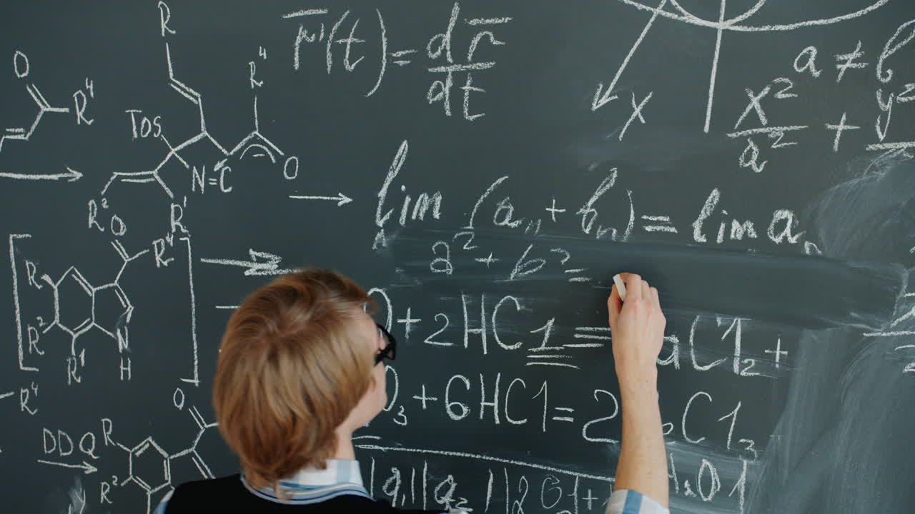 Student working on a chalkboard with mathematical and chemical equations