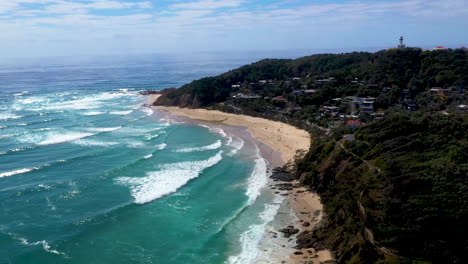 wide drone shot of surfers in the ocean at wategos beach in australia
