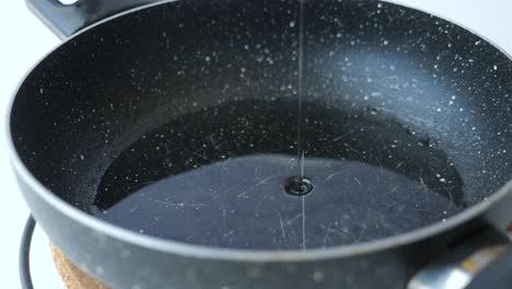 pouring oil into a frying pan