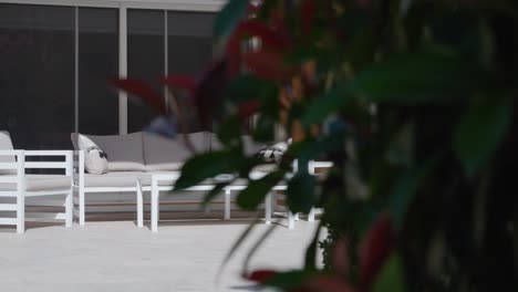 Slow-revealing-shot-of-outdoor-garden-furniture-sat-in-the-sun-in-a-garden