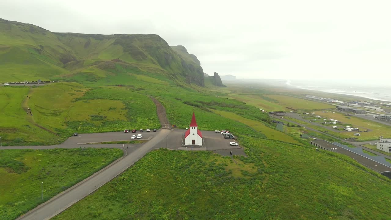 The drone footage highlights the rugged coastline of Vik, showcasing the impressive sea stacks of Reynisdrangar and the breathtaking interplay of light and shadow.