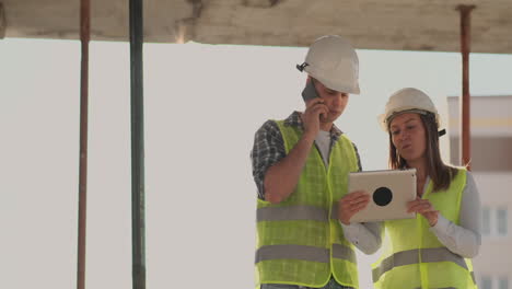 the controller is a man of a building under construction talking on the phone with management and has discussed with the engineer and architect woman construction progress.