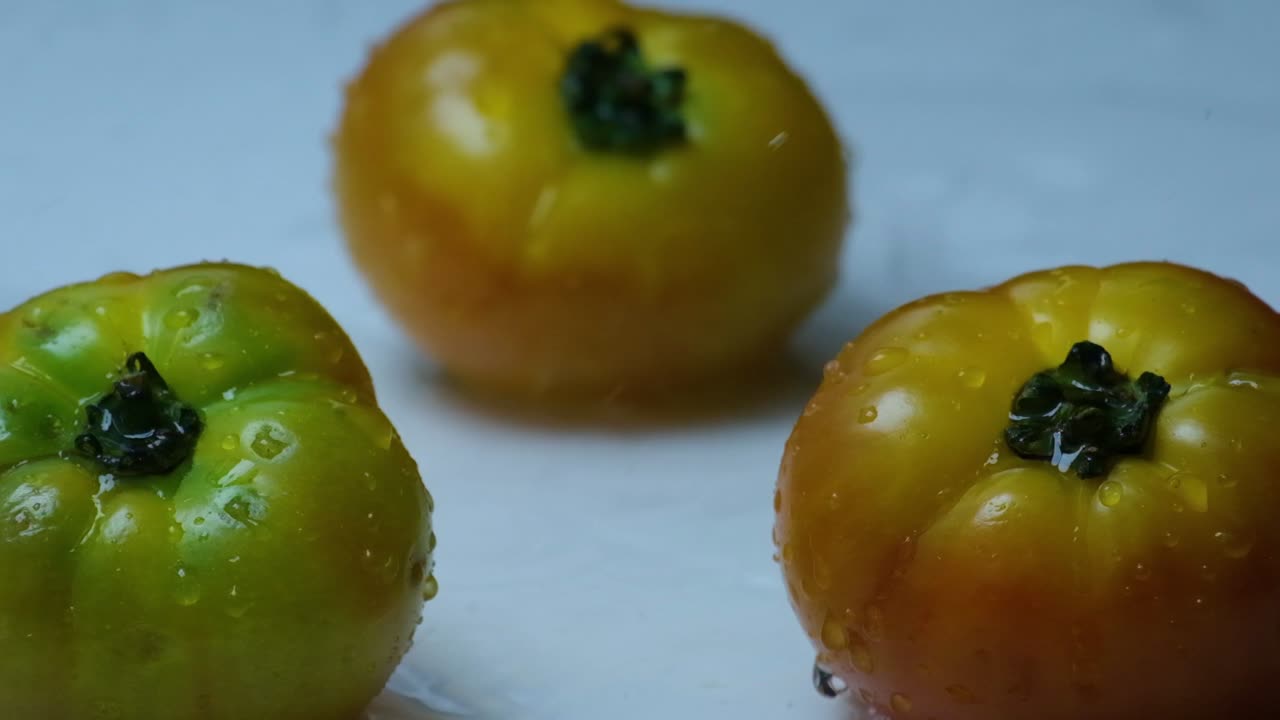 salpicaduras de agua caen sobre los tomates de la herencia