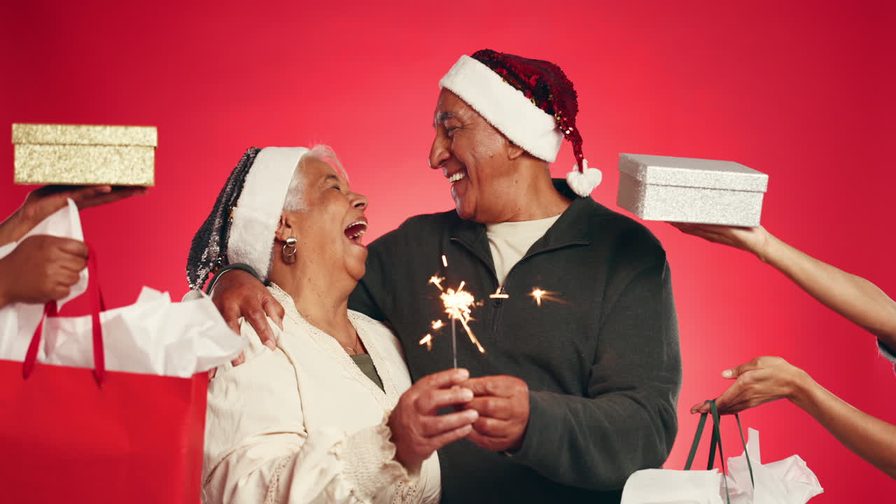 Elderly couple celebrating Christmas with gifts and sparklers