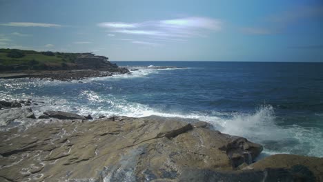 olas azules rompiendo en una costa rocosa - playa vacía de clovelly - suburbios del este - sydney, nueva gales del sur, australia