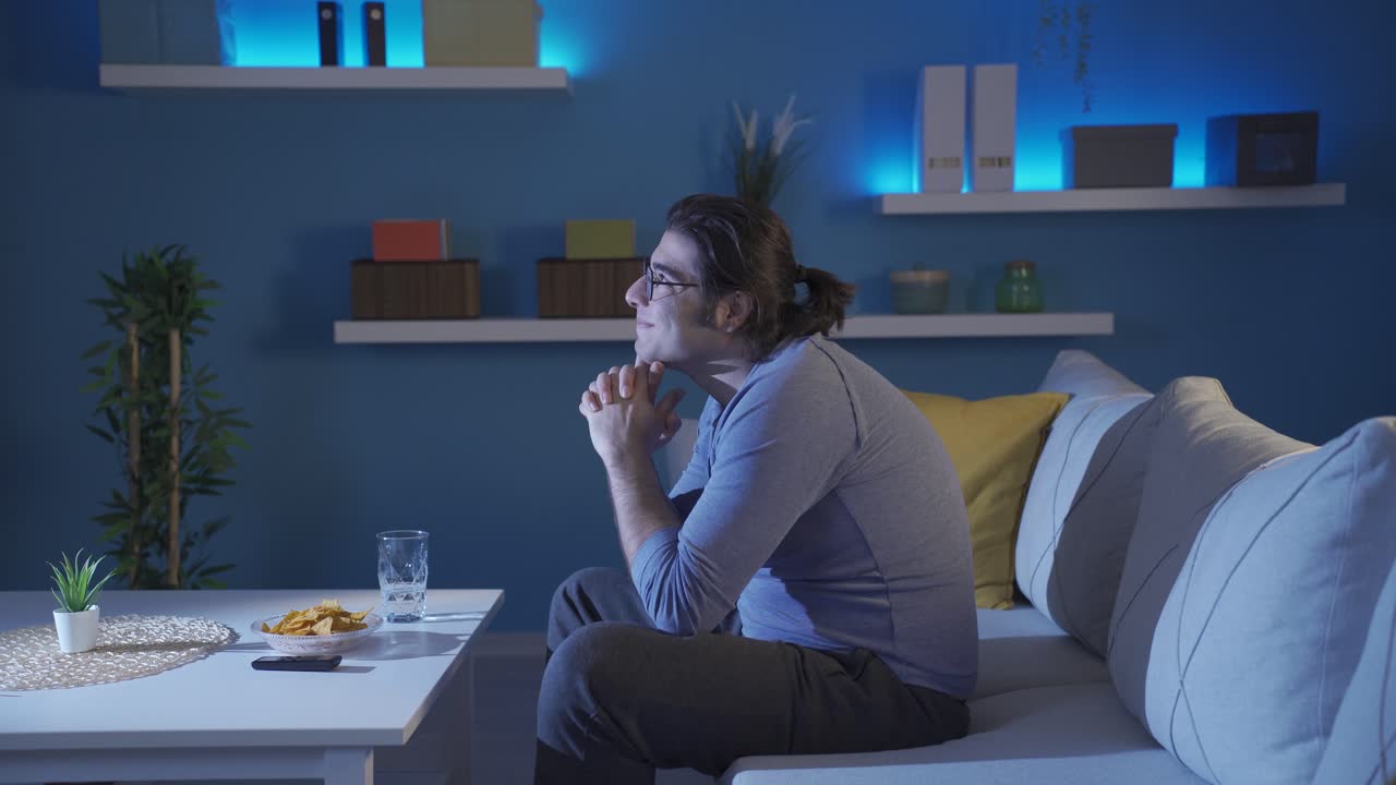 Jovem pensativo e feliz sozinho em casa. Ele está satisfeito com a vida