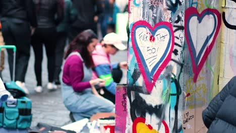 artists creating heart graffiti on hosier lane wall