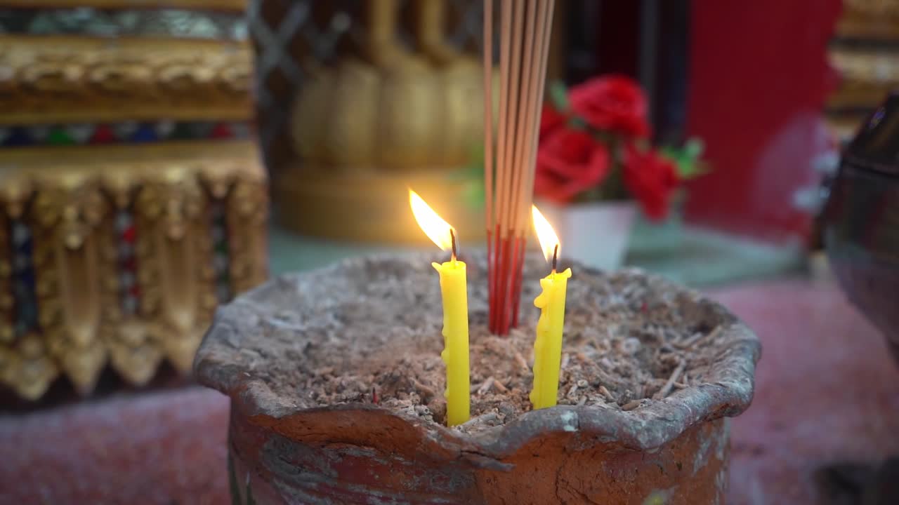 imágenes de velocidad 120 de velas amarillas encendidas en un templo para encender incienso para guiar la meditación