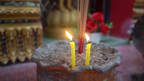 120 speed footage of yellow candles burning at a temple to light incense for guiding meditation