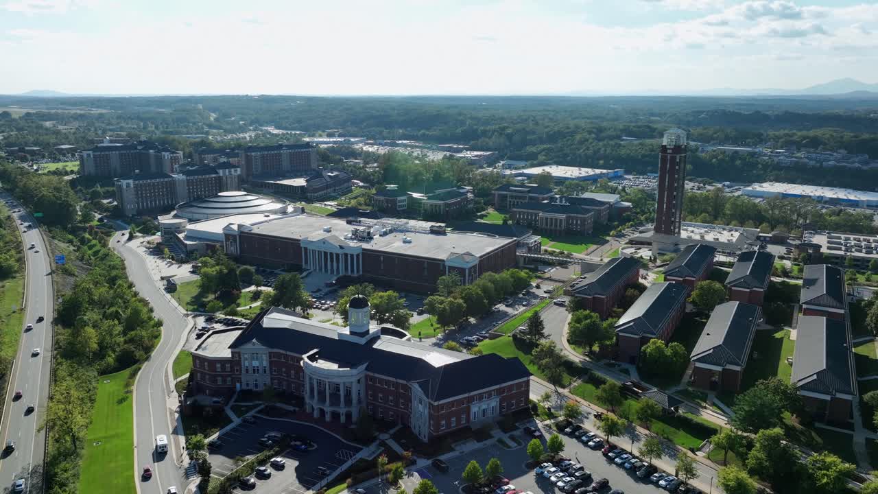 Drone flight over historic and upscale liberty university in Virginia. Late summer day in America. Traffic on interstate highway of Lynchburg. Beautiful old buildings and roofs of houses