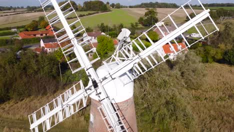 billingford windmill at road side field area with house in diss, norfolk - aerial drone flying shot