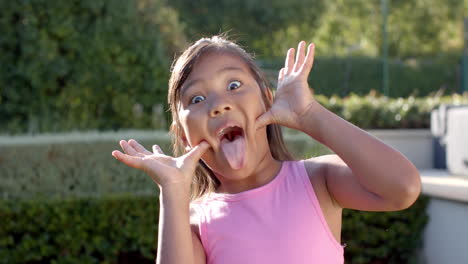 making funny face, girl in pink tank top enjoying outdoor playtime