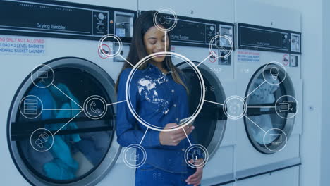 digital communication icons animation over woman using smartphone in laundromat