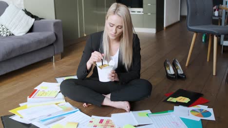 Young-business-woman-working-and-eating-asian-food