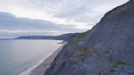 Drone-Disparó-Volando-Hacia-Atrás-A-Lo-Largo-De-Un-Acantilado-En-La-Costa-Jurásica,-Dorset,-Reino-Unido