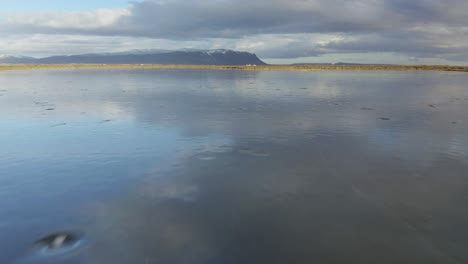 scenic frozen lake with sky reflections during winter in olfusa river near selfoss, iceland
