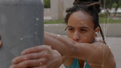 Animation-of-network-of-connections-over-biracial-woman-stretching-on-street