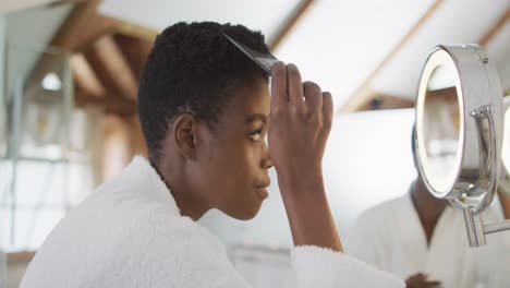 Mujer-Atractiva-Afroamericana-Cepillándose-El-Cabello-En-El-Baño.