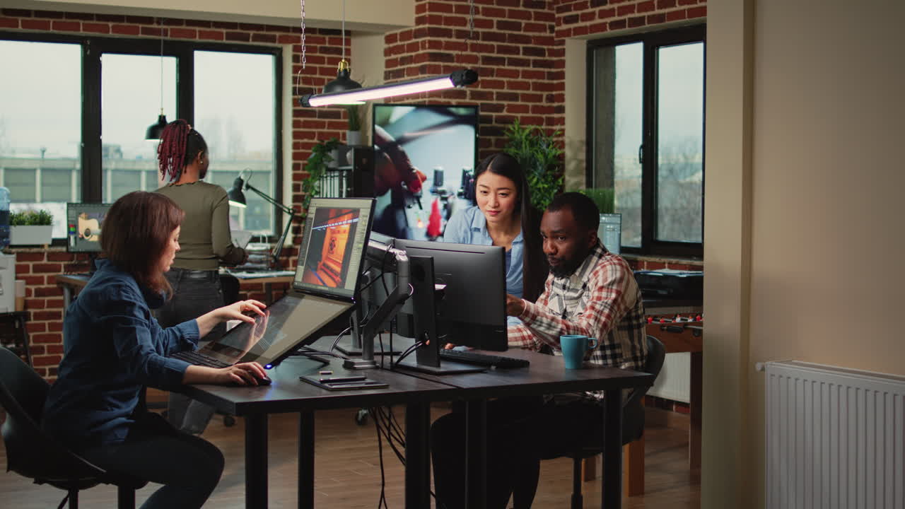 Modern technology studio employees using computers to develop new graphics