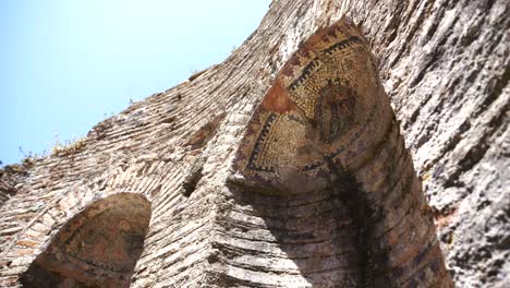 butrint, albania, mosaicos de cerámica en ventanas arqueadas de un antiguo edificio de piedra