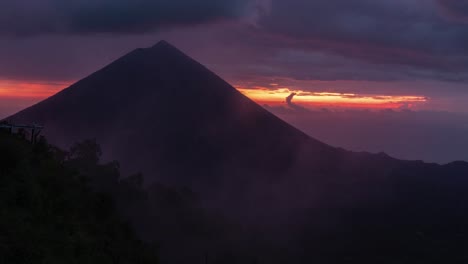 dramatic sunrise or sunset over a silhouetted volcano