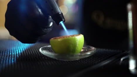 cantinero llameante cítricos de limón con azúcar para la preparación de cócteles a cámara lenta