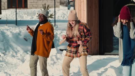 christmas holiday fun. group of happy multiethnic young friends dance together at snowy winter house party slow motion.