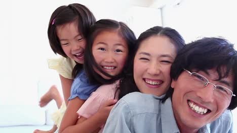 family playfully lying on each other