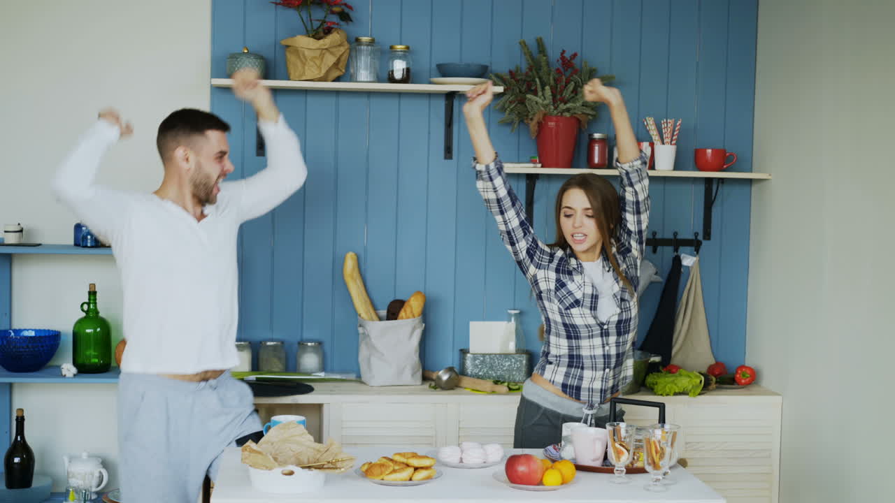 pareja feliz bailando en la cocina