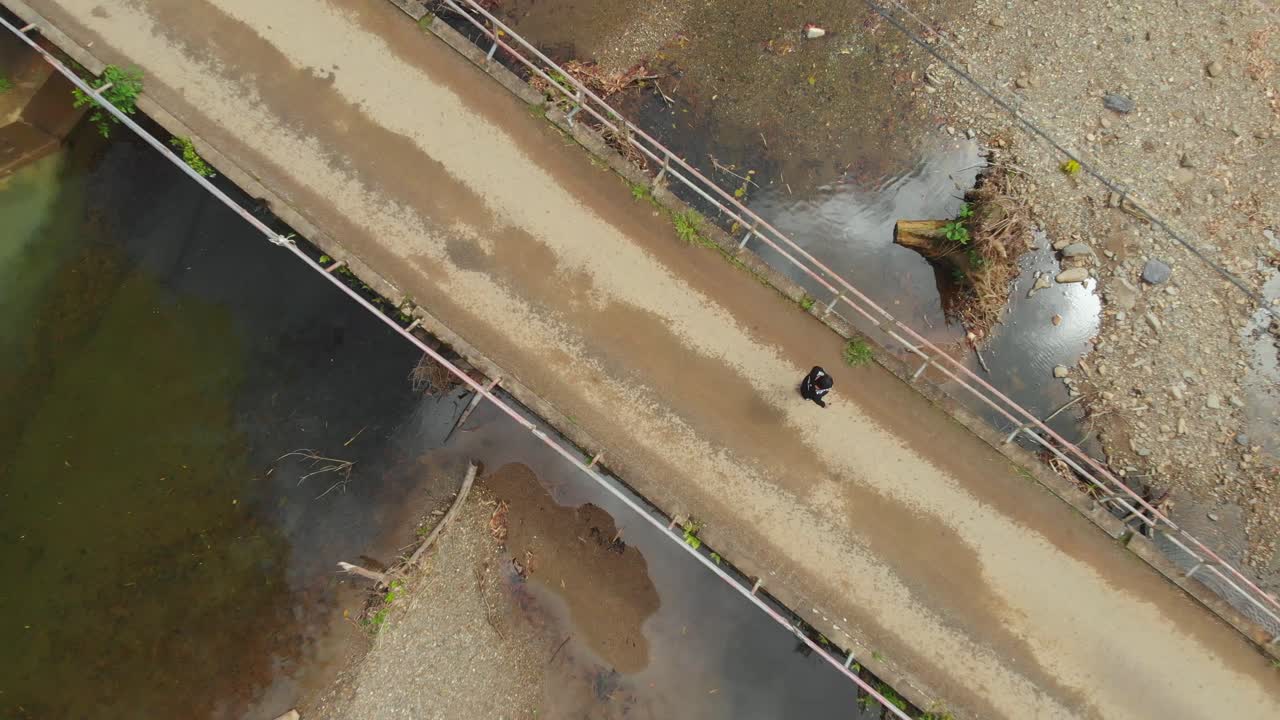 una niña camina sobre un puente con un río que fluye debajo de ella en el pueblo norteño de grande riviere, trinidad y tobago