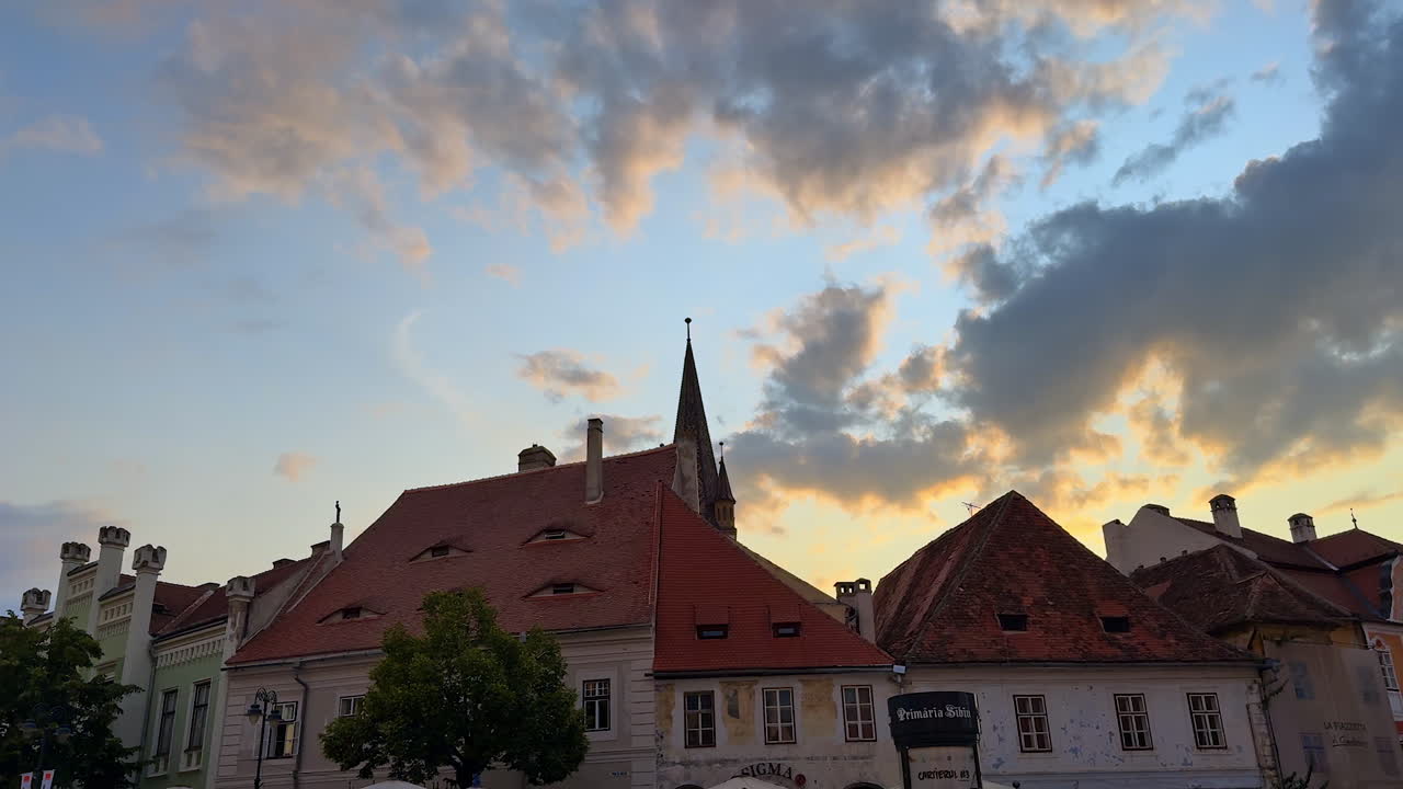 Sibiu, Romania, 17 luglio 2025: veduta serale della strada nel centro storico di Sibiu. Case storiche con tetti rossi e cielo al tramonto a Sibiu, Romania