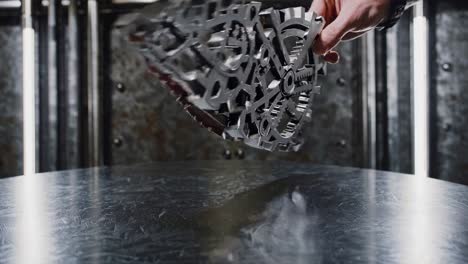man holding a metal gear clockwork mechanism