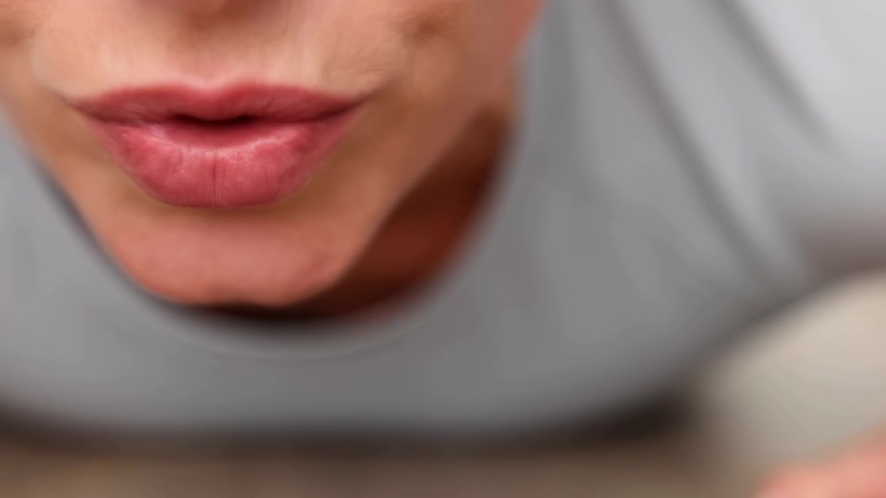 Labbra che si muovono e cambiano posizione, in primo piano del viso di una persona, con labbra, denti, con la texture della pelle, del tessuto dell'abbigliamento, da una prospettiva frontale ravvicinata, con accenti rosa e grigi
