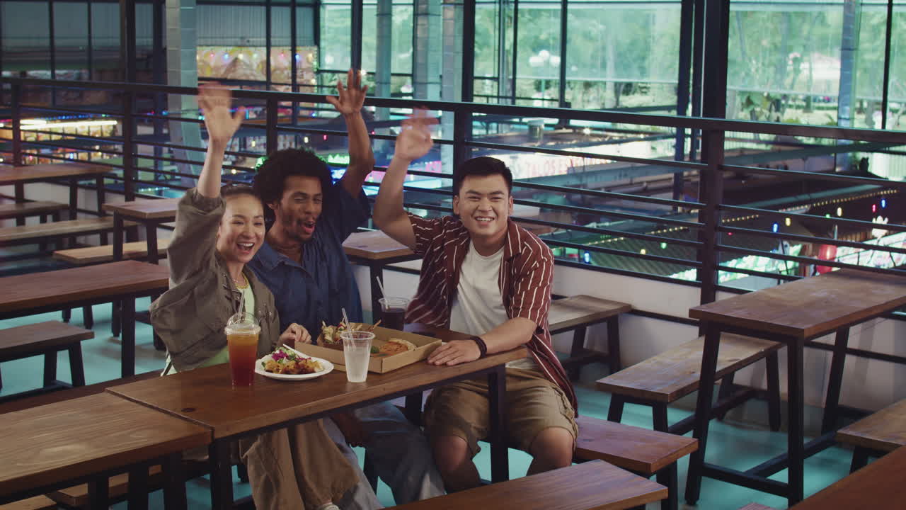 Friends Greeting Someone at Street Food Cafe