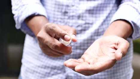 close up of young man hand using hand sanitizer spray