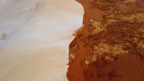 aerial birdseye over white and red sand dunes connecting, vietnam