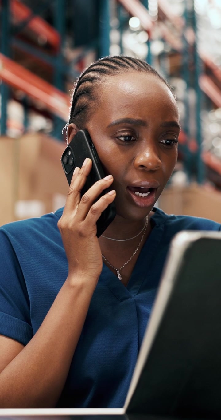 Warehouse Manager Talking on Phone While Reviewing Digital Tablet
