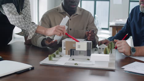 diverse team of architects discussing building model