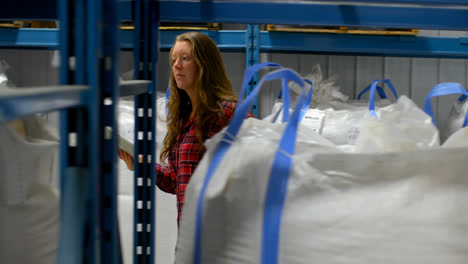Front view of caucasian female worker checking stocks in warehouse 4k