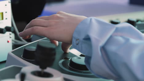 scientist operating microscope controls in a laboratory setting