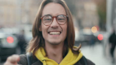 vista de cerca de un joven hipster alegre con anteojos haciendo diferentes caras graciosas y haciendo muecas a la cámara en la calle