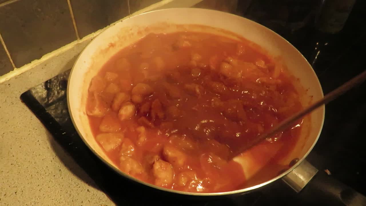 timelapse de una salsa de tomate roja con pollo brillante, en preparación de una receta