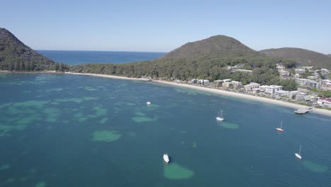 Vista-Aérea-De-Veleros-Flotando-En-Las-Tranquilas-Aguas-Azules-De-Shoal-Bay-En-Port-Stephens,-Nsw,-Australia